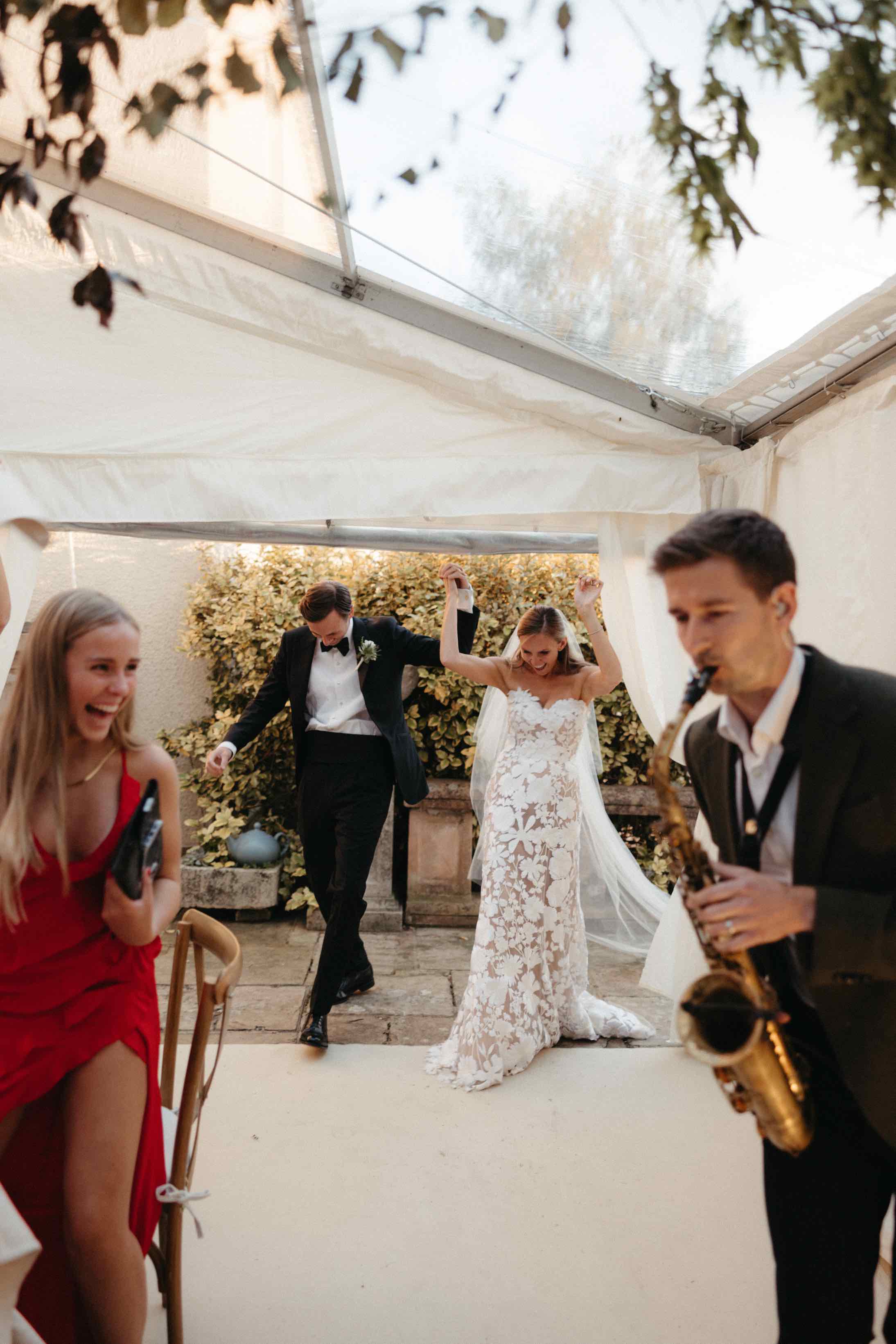 Katie & Cal's wedding - welcome into marquee with sax